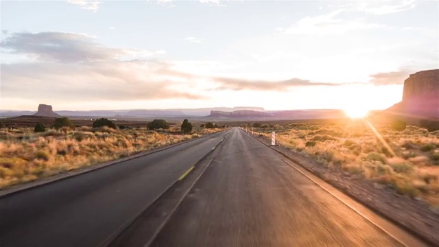 驾驶美国:壮观的日落驾驶拍摄沿着孤独的道路在美国沙漠