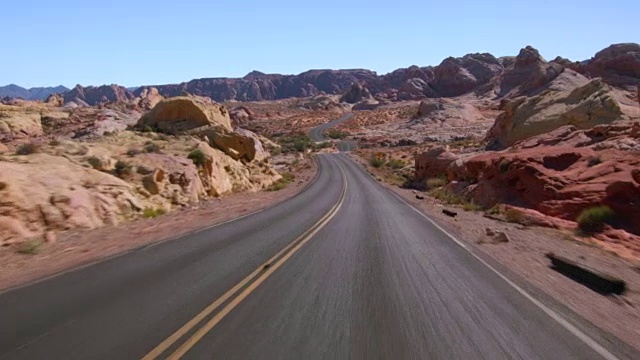 驾驶美国:汽车POV沿着空沙漠道路通过火谷，内华达州