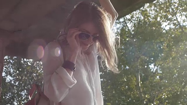 詳情圖-戴著眼鏡的女孩模特在一座廢棄建筑的廢墟上為相機擺姿勢
