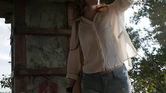 詳情圖-戴著眼鏡的女孩模特在一座廢棄建筑的廢墟上為相機擺姿勢