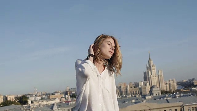詳情圖-那個漂亮的女孩在一座廢棄建筑的屋頂上做模特。頭發(fā)在風中飄揚