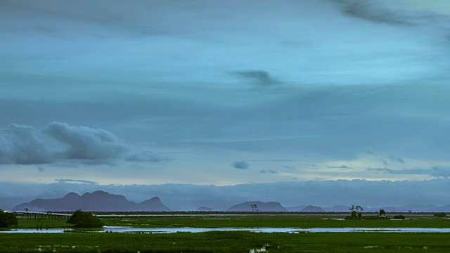 极简黄昏云漂移在平坦的牧场湿地延时