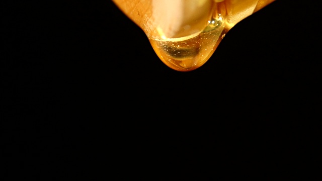 詳情圖-蜂蜜在滴落，一滴，在黑色上，特寫