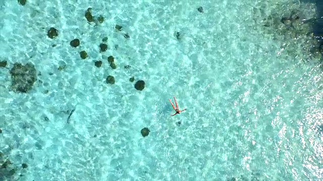 詳情圖-空中慢鏡頭:美麗的年輕女子游泳，躺在清澈的海面上