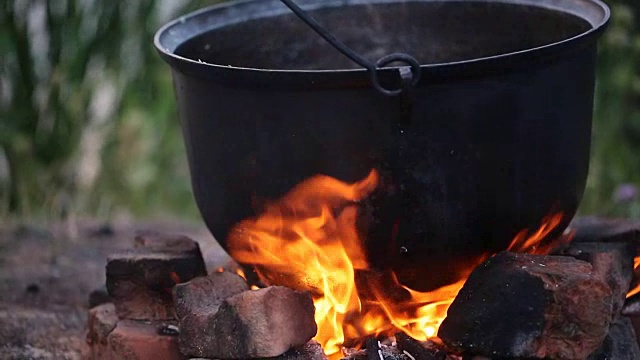 野餐在大锅下生火，钓鱼后喝鱼汤