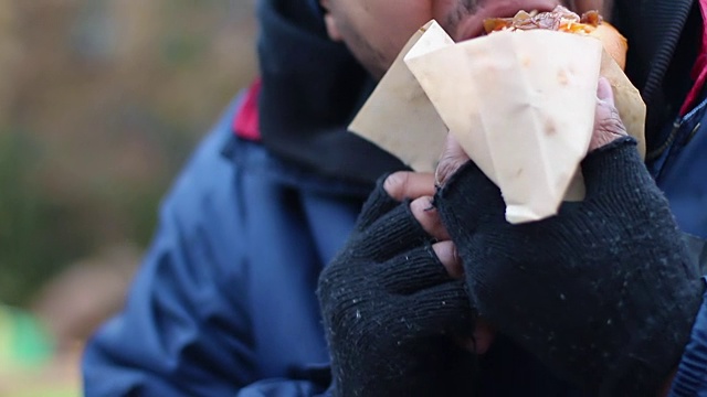 男性垃圾食品成瘾，咬着吃着油腻的热狗，