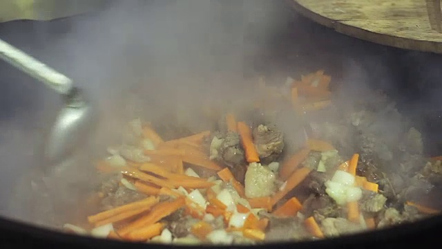 街头小贩在美食节上烹煮蔬菜和肉，