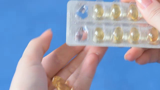 詳情圖-手從水泡里拿出藥丸，維生素E