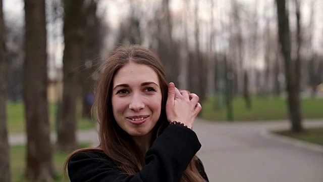 詳情圖-年輕漂亮的女孩戴著一頂黑帽子愉快地對著鏡頭微笑，特寫，慢鏡頭