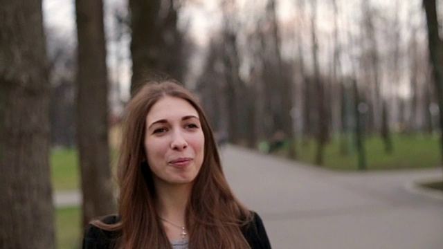 詳情圖-年輕漂亮的女孩戴著一頂黑帽子愉快地對著鏡頭微笑，特寫，慢鏡頭