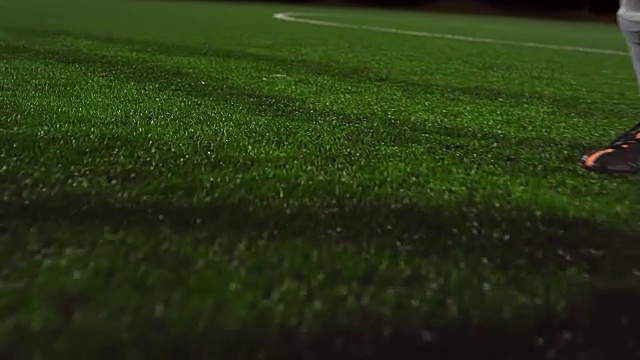 詳情圖-一名女子足球運動員晚上在對手鏟球和防守時運球穿過球場