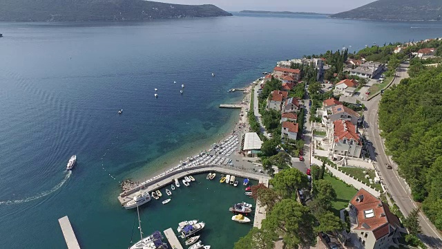 跟随游客的船，鸟瞰图，地平线和亚得里亚海海湾的游艇，海滩，房屋道路，和黑山海岸的绿化