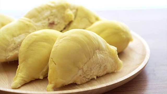 木盘上的成熟榴莲发黄发臭。热带夏季水果与仿空间