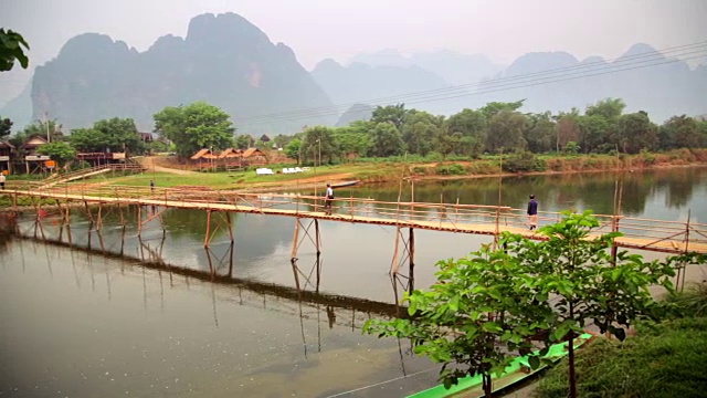 人们通过竹桥在石灰石山的背景