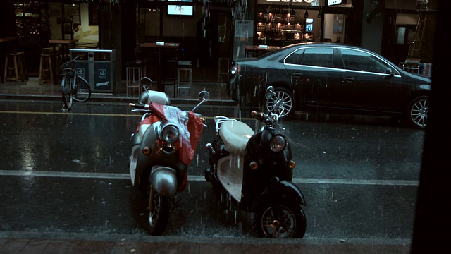 在上海永康路，摩托车在雨中停在路上。