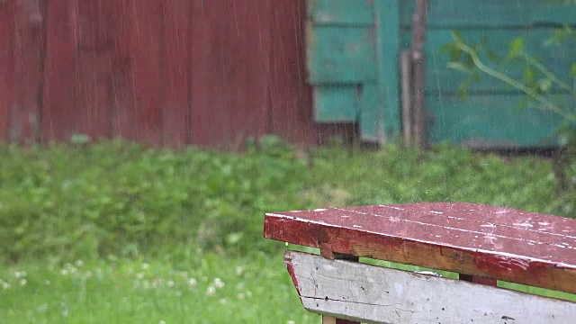 大雨水滴落在木质的室外表面。