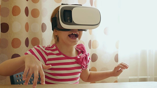 小女孩愉快地使用VR显示耳机。