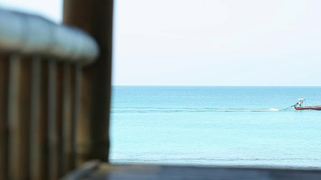 有渔船和黄沙的热带海滩。美丽的云和海浪的大海。