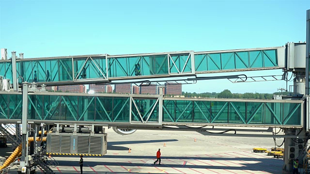 詳情圖-乘客通過北京國際機場的一條玻璃通道走出飛機。
