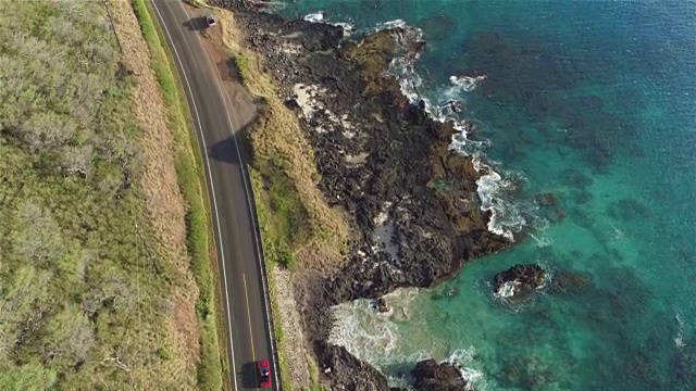 航拍:红色敞篷车在海洋悬崖上美丽的海岸公路上行驶