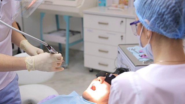 详情图-牙科医生正在用牙科设备或器械进行牙齿美白或其他口腔手术