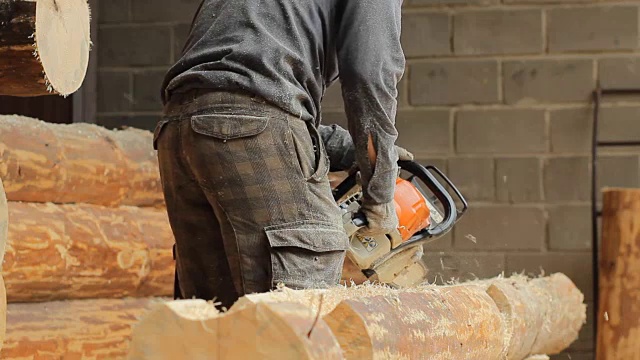 人切断梁链锯为未来的木屋。建筑工程采用木结构