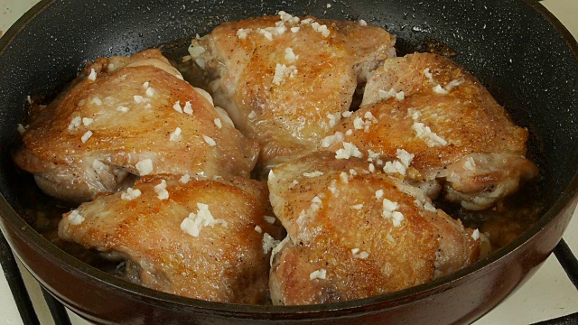 煎锅里的鸡腿。