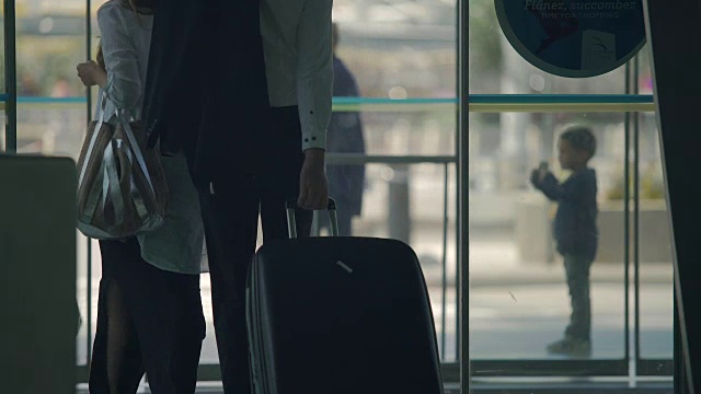 女性和男性旅客走出机场的自动开门