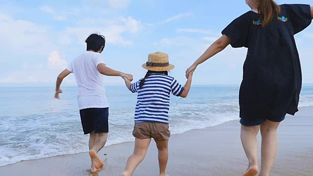 泰国普吉岛，快乐亚洲一家一起在沙滩上奔跑的慢镜头