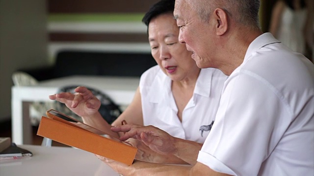 详情图-亚洲资深夫妇一起阅读新闻平板电脑在小图书馆。学习与研究概念