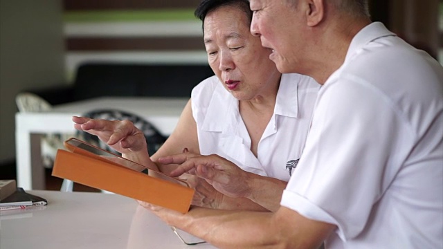 详情图-亚洲资深夫妇一起阅读新闻平板电脑在小图书馆。学习与研究概念