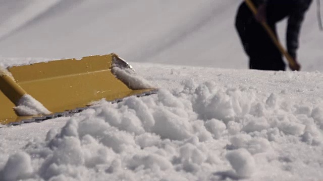 詳情圖-在滑雪勝地，人們用鐵鏟清除積雪。陽(yáng)光明媚的一天。山。噴灑。雪堆