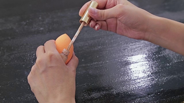 近距离拍摄女人的手打开轮廓脸部化妆遮瑕工具