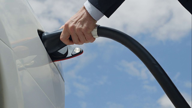 詳情圖-特寫:商人正在充電的白色電動車