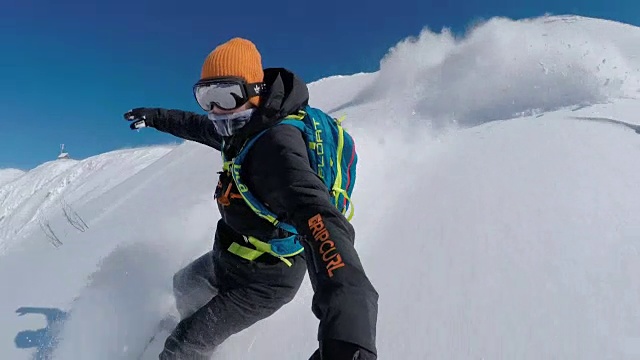 自拍:极限自由滑板滑雪者在山上越野滑雪道上做粉状转弯