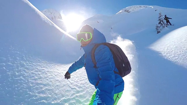 在雪山的偏远地区，极限免费滑雪滑雪者在粉末雪中滑行