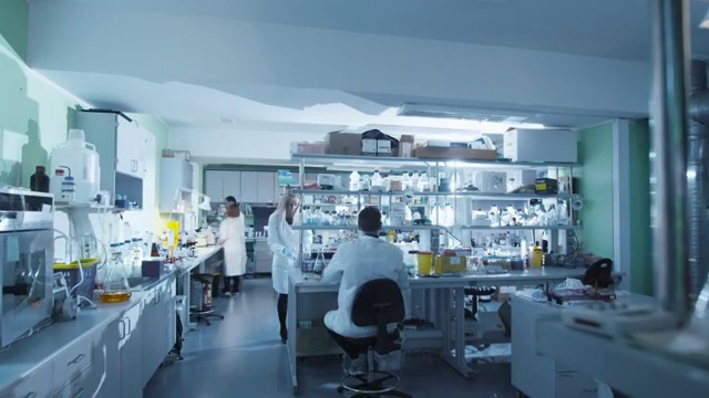 详情图-一组穿着白大褂的科学家在现代实验室里工作的镜头。