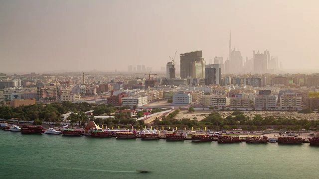 迪拜城市日落市中心德拉屋顶顶部小溪全景4k时间流逝阿拉伯联合酋长国