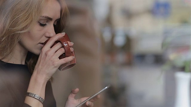 详情图-拿着智能手机在咖啡馆喝咖啡的女商人