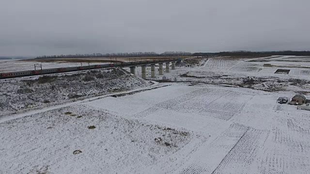 火车沿着铁路行驶。旅客列车和车厢。冬季。空中