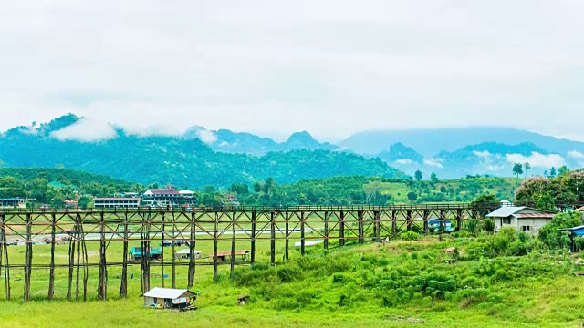 美丽的木桥穿越河与雾和山在早晨的时间流逝