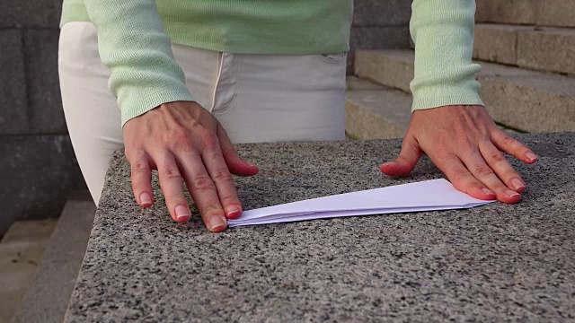女人折叠白色折纸飞机