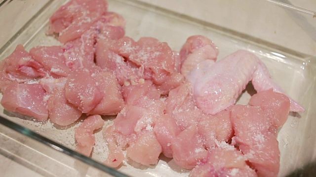 女人的手把肉片和香料混合在一起
