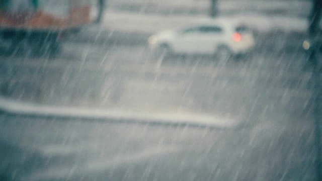 雪花飘落在汽车模糊的道路上