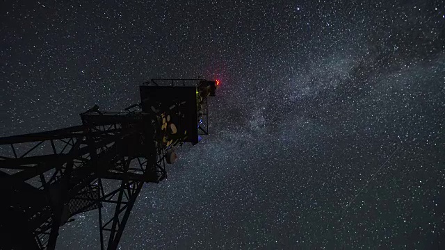 通信塔在星夜时间流逝。移动的星星与银河系一起天空