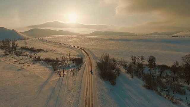 黄昏时分，几辆汽车在结冰的路上行驶