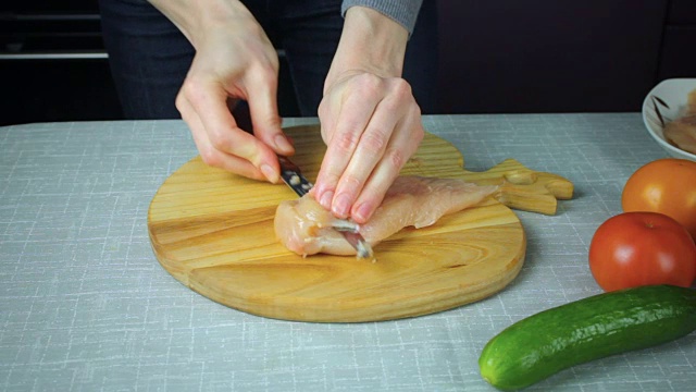 女孩切了一块生鸡肉