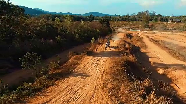 航拍:男子在越野摩托车跑道上跳跃。