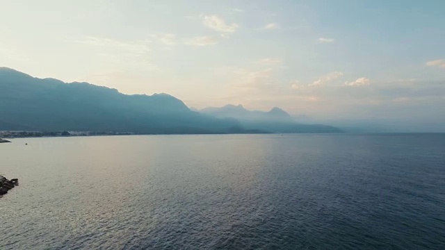 鸟瞰宽拍摄POV视图飞过海湾在地中海日落，在4K超高清拍摄