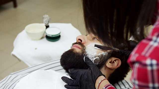 理发师用剃须刀给一个白人刮胡子